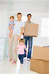 Family with box moving into new home smiling