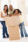 Family with boxes in new home smiling