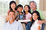 Family in living room with cake smiling