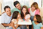 Family in living room with cake smiling