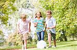 Three young friends playing soccer