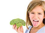 Young girl holding broccoli and sticking tongue out