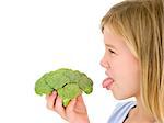 Young girl holding broccoli and sticking tongue out