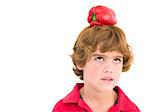 Young boy with red pepper on his head frowning