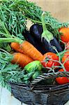 Mix fresh vegetables (carrots, eggplant, cucumbers, tomatoes) in a black wicker basket