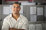 Confident office worker smiles in his office cubicle