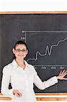 Dark-haired teacher explaining charts to students in a classroom