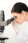 Female scientist looking through a microscope in a lab