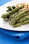 Asparagus gratin on white plate on blue background