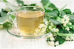 Cup of tea and linden flowers on wooden background