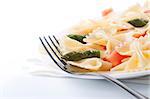 Pasta farfalle, tomato and asparagus salad on white background