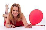 mature woman lying, holding a ballon, isolated on white, studio shot