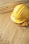 Construction background. Yellow helmet on wooden floor.