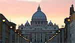 View on illuminated lammposts leading towards Saint Peter Basilica in Vatcan at evening.