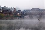 China river landscape with boat, bridge and ancient building in Fenghuang county, Hunan province, China