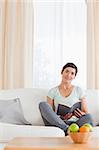 Lovely woman holding a book while looking at the camera