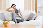 Cute woman reading a book in her living room