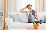 Charming woman reading a book in her living room