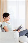 Portrait of a short-haired woman reading a book in her liviing room