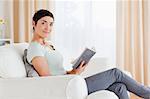 Short-haired brunette holding a book while looking at the camera