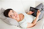 Cute woman using a tablet computer in her living room