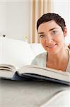 Portrait of a short-haired woman with a book looking at the camera