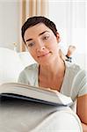 Portrait of a short-haired woman reading a book in her living room