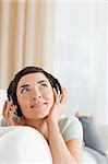 Portrait of a short-haired woman listening to music looking up