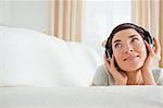 Cute short-haired woman listening to music looking up
