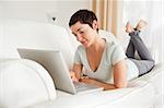 Smiling short-haired woman using a laptop in her living room