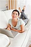 Portrait of a dark-haired woman with a laptop looking at the camera