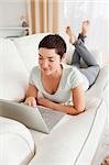 Portrait of a dark-haired woman using a laptop in her living room