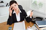 Thoughtful accountant checking receipts in her office