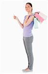 Good looking woman with a credit card holding shopping bags while standing against a white background