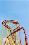 Roller coaster in amusement park under blue sky