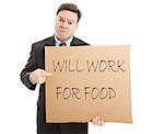Desperate, unemployed businessman holding up a message on a cardboard box that says "Will Work For Food".