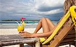 Woman enjoying a cocktail on a tropical beach