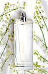 Lily of the valley and perfume bottle on white silk