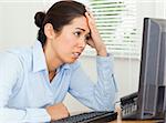 Attractive upset woman looking at a computer screen while sitting at the office