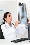 Pretty female doctor looking at a x-ray in her office