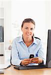 Businesswoman sending a text message in her office