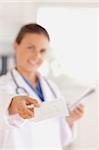 Smiling brunette doctor handing out a prescription in the surgery