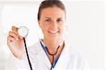 gorgeous doctor showing stethoscope to the camera in her surgery