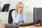 Frustrated working woman in front of a screen in an office