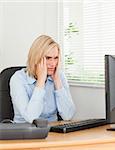 Frustrated working woman looking at a screen in an office