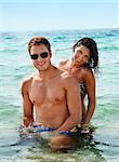 Beautiful smiling young couple having fun in the sea