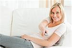 Woman pointing a remote at the camera in her living room