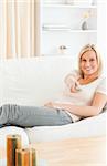 Portrait of a smiling woman using a remote in her living room