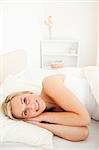 Portrait of a gorgeous blonde woman waking up in her bedroom