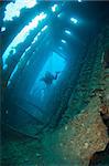 Scuba diver exploring the interior of a large shipwreck